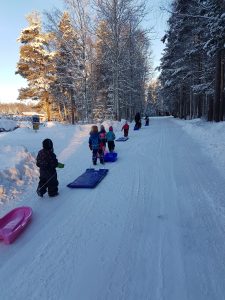 barn på väg till pulkabacken.